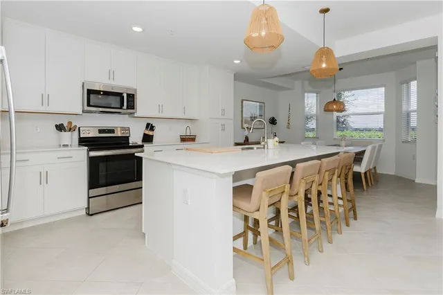a kitchen with stainless steel appliances kitchen island granite countertop a table and chairs in it