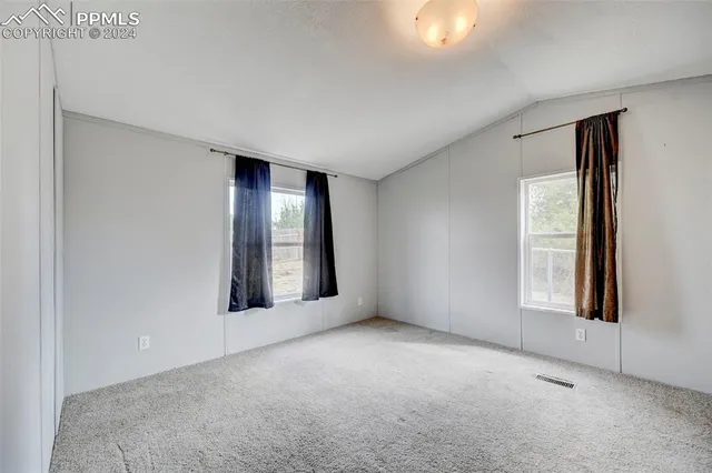an empty room with windows and closet