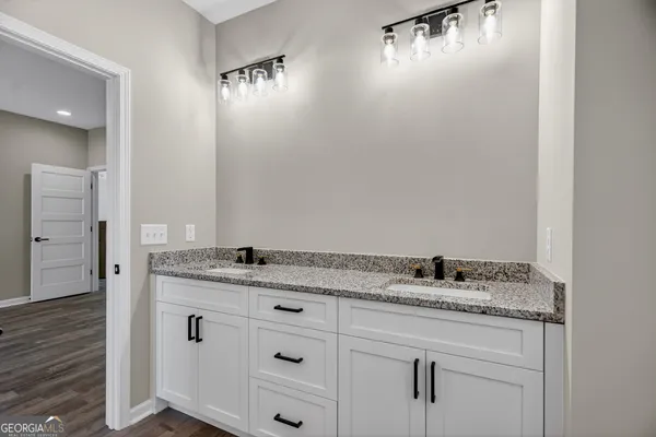 a bathroom with a granite countertop sink and a mirror