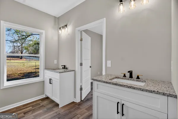 a en suite bathroom with a granite countertop sink and a mirror