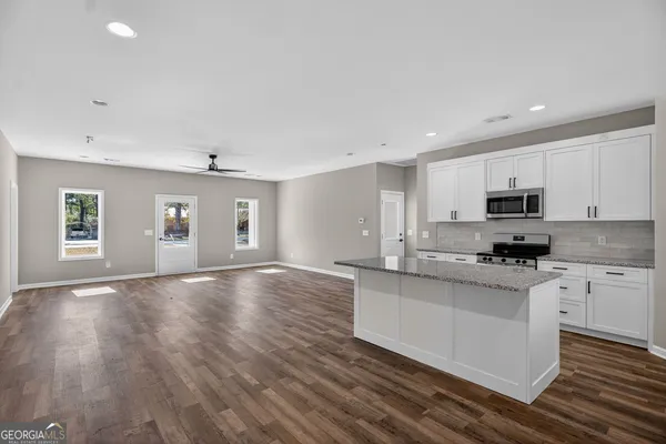 a kitchen with granite countertop a stove and cabinets