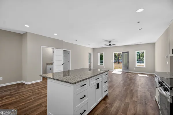 a kitchen with granite countertop a sink and wooden floor