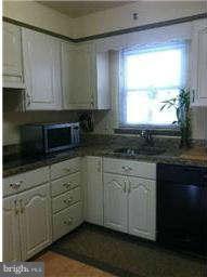 8514 Stevenswood Road Baltimore, MD 21244 - Photo 2 of 15 a kitchen with granite countertop white cabinets stainless steel appliances a window and a sink