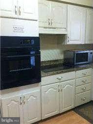8514 Stevenswood Road Baltimore, MD 21244 - Photo 4 of 15 a kitchen with white cabinets and appliances