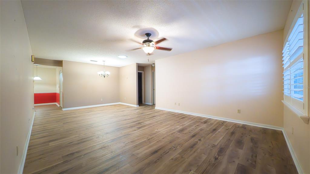 9357 Southwest 82nd Terrace, Unit C Ocala, FL 34481 - Photo 11 of 30 a view of an empty room with chandelier fan and a window