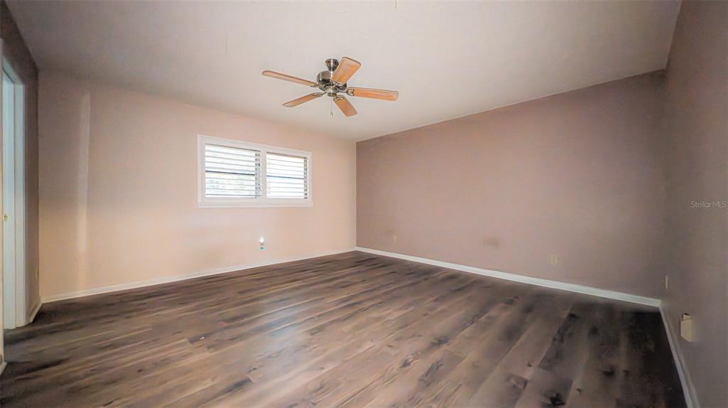 9357 Southwest 82nd Terrace, Unit C Ocala, FL 34481 - Photo 19 of 30 a view of an empty room with wooden floor and a window