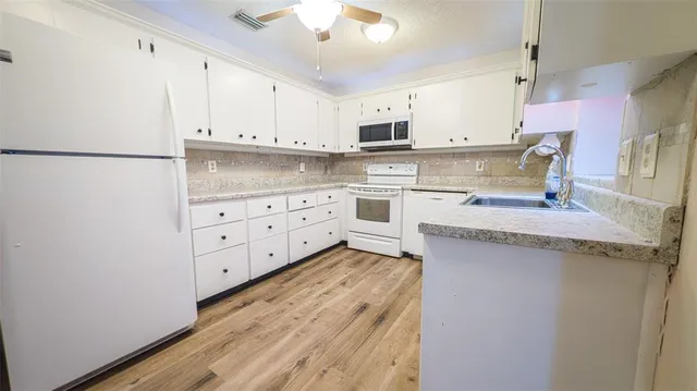 a kitchen with stainless steel appliances granite countertop a sink dishwasher and a refrigerator