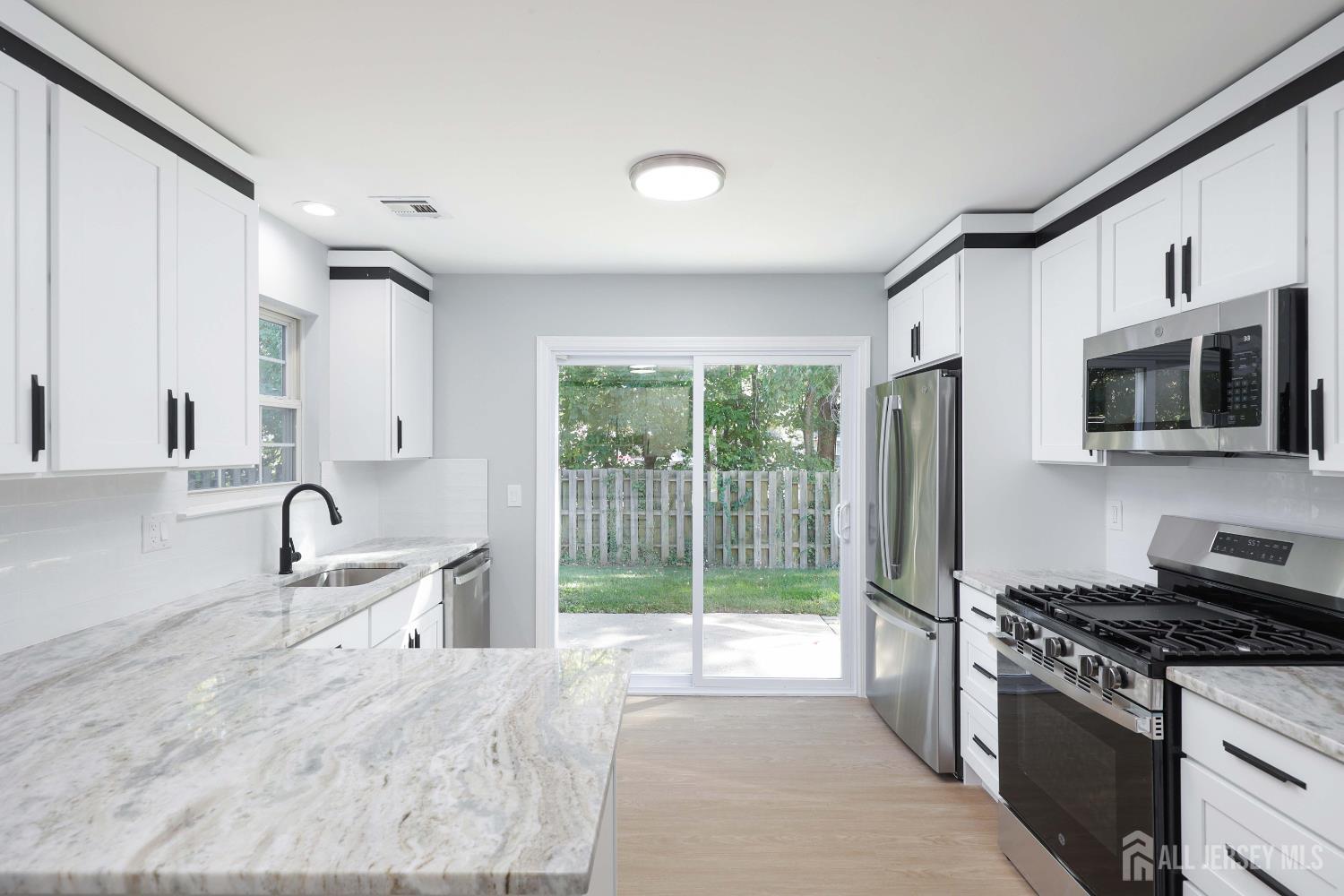 4 Ellison Court Keyport, NJ 07735 - Photo 12 of 37 a kitchen with granite countertop a sink and a stove top oven