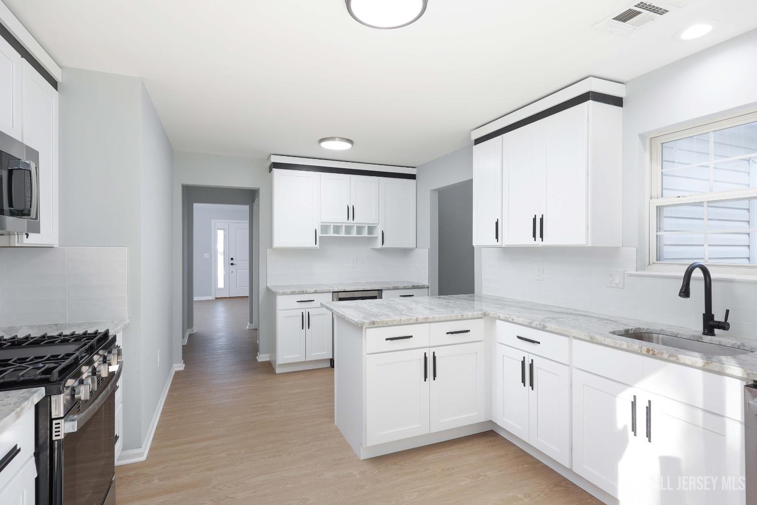 4 Ellison Court Keyport, NJ 07735 - Photo 14 of 37 a kitchen with white cabinets and appliances