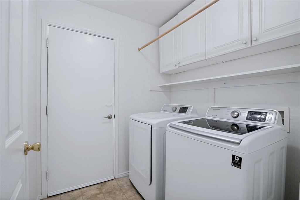 3111 Creekside Drive Sachse, TX 75048 - Photo 22 of 25 Dedicated laundry area featuring overhead cabinetry, open shelving, and a wooden hanging rod