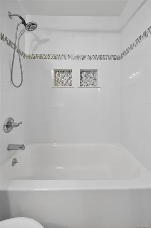 a bathroom with a sink toilet a mirror and bathtub