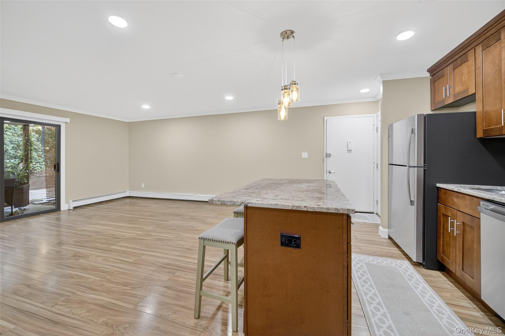 10 Secora Road, Unit L12 Monsey, NY 10952 - Photo 23 of 24 an empty room with wooden floor and a kitchen