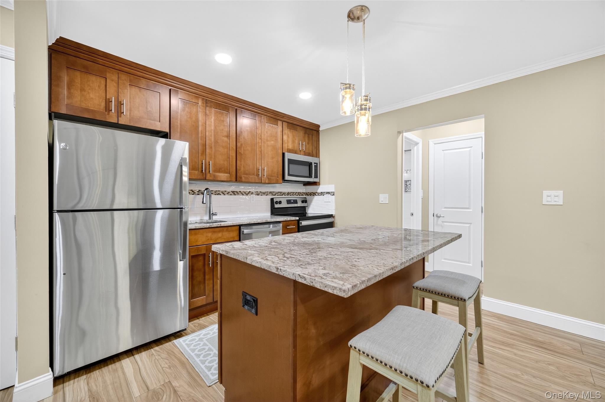 10 Secora Road, Unit L12 Monsey, NY 10952 - Photo 3 of 24 a kitchen with stainless steel appliances granite countertop a refrigerator a sink dishwasher a stove and a refrigerator with wooden floor