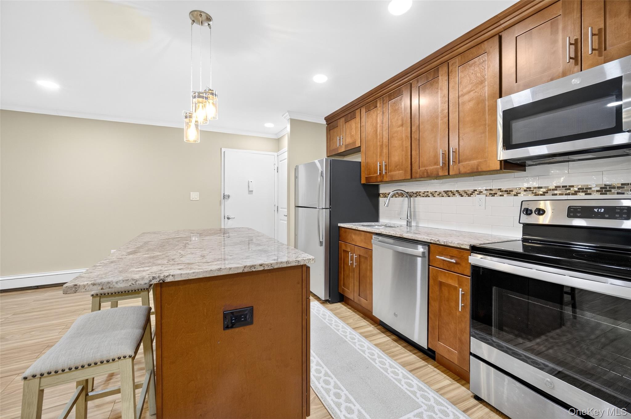 10 Secora Road, Unit L12 Monsey, NY 10952 - Photo 5 of 24 a kitchen with stainless steel appliances granite countertop a stove a sink and a microwave