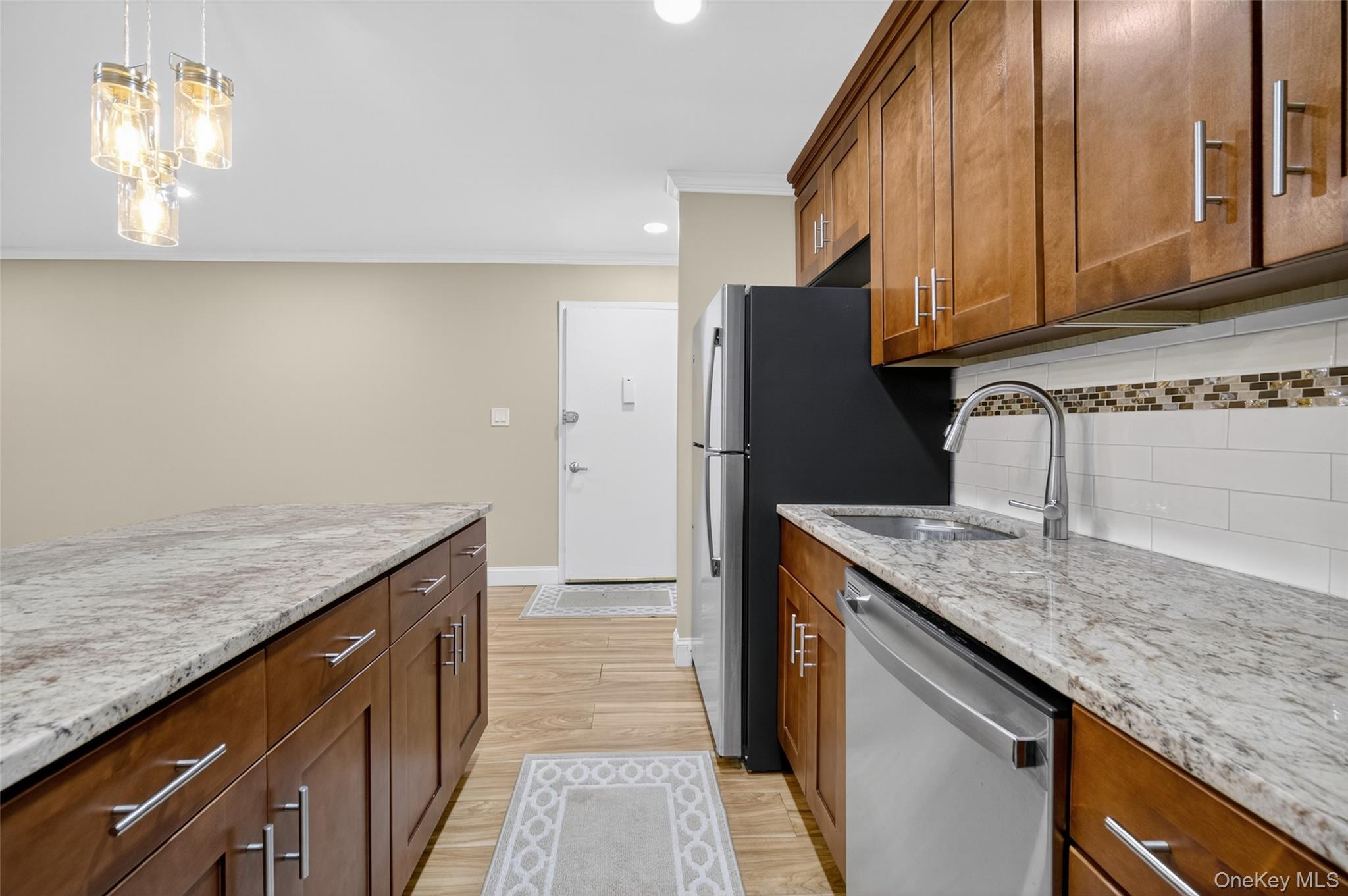 10 Secora Road, Unit L12 Monsey, NY 10952 - Photo 6 of 24 a kitchen with granite countertop stainless steel appliances a sink stove and refrigerator