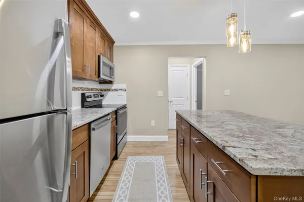 a kitchen with stainless steel appliances granite countertop a stove a sink and a microwave