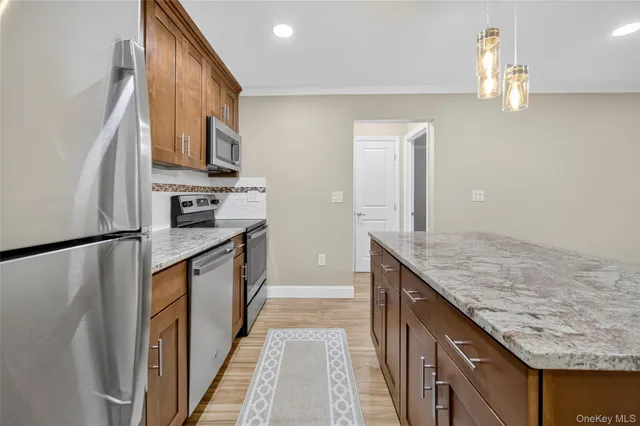 a kitchen with stainless steel appliances granite countertop a stove a sink and a microwave