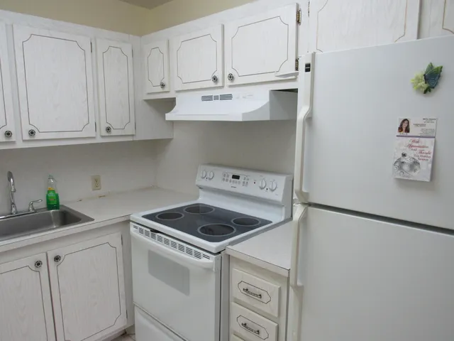a kitchen with white cabinets and white appliances