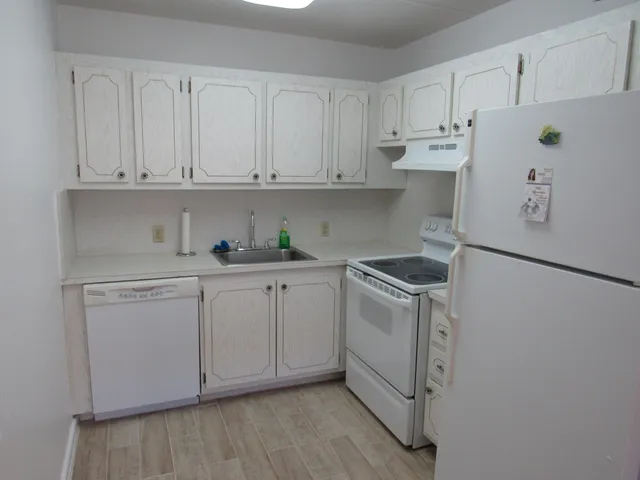 a kitchen with white cabinets and white appliances