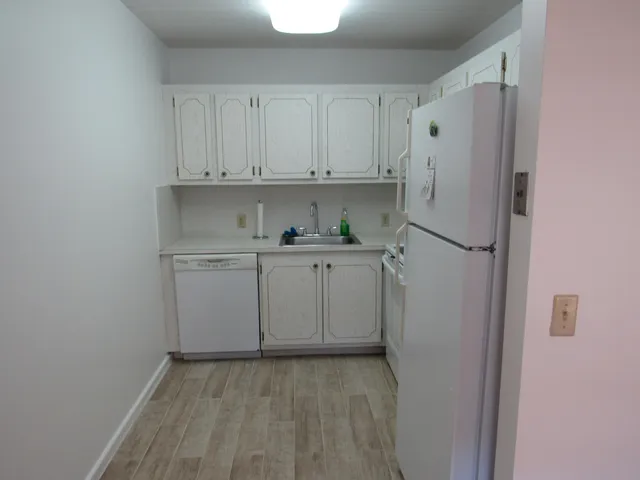 a view of cabinets a sink and a stove in a kitchen