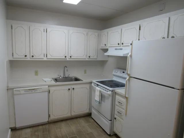 a kitchen with stainless steel appliances granite countertop white refrigerator stove top oven and cabinets