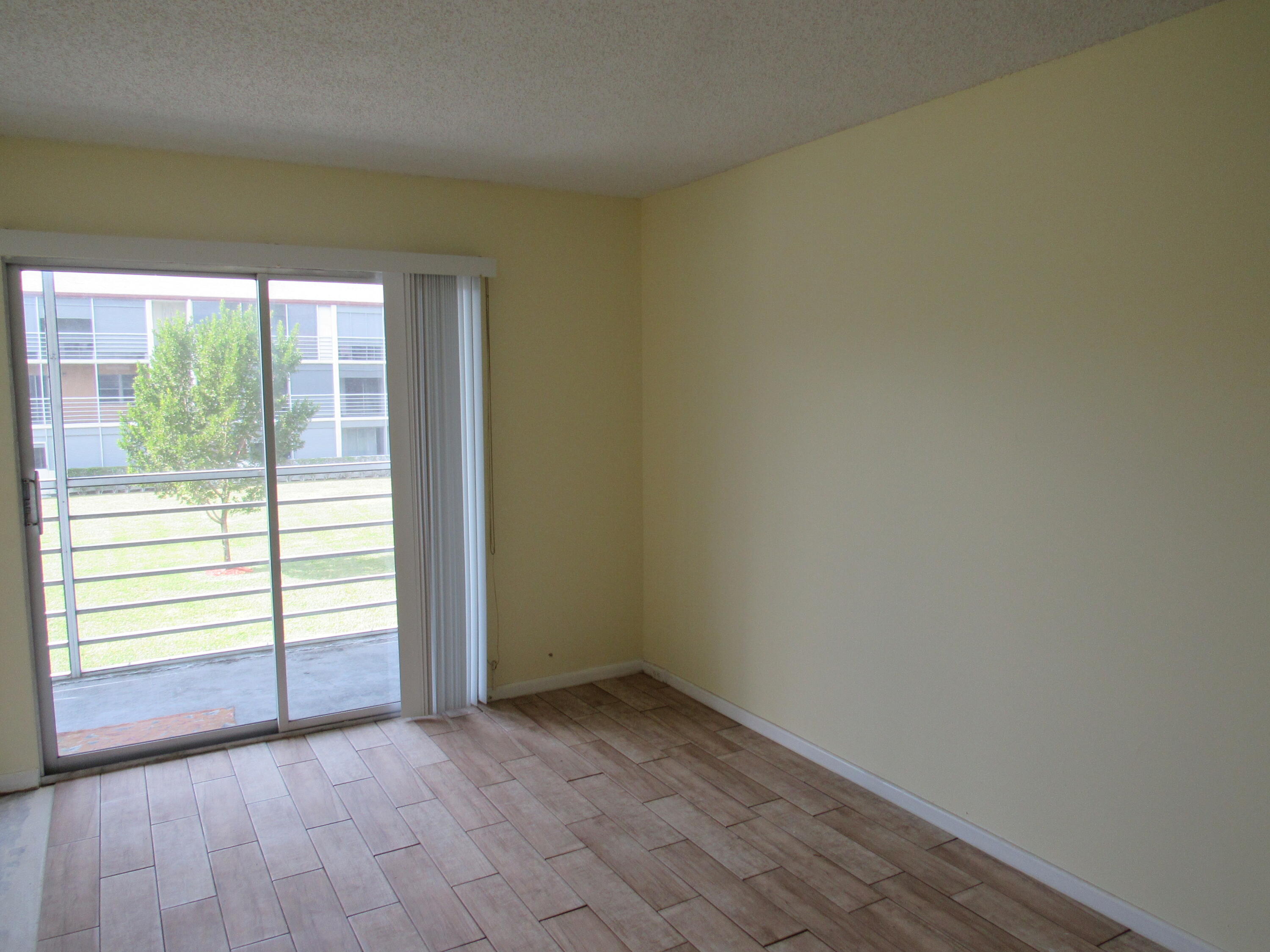 310 Brighton H Boca Raton, FL 33434 - Photo 19 of 41 an empty room with wooden floor and windows