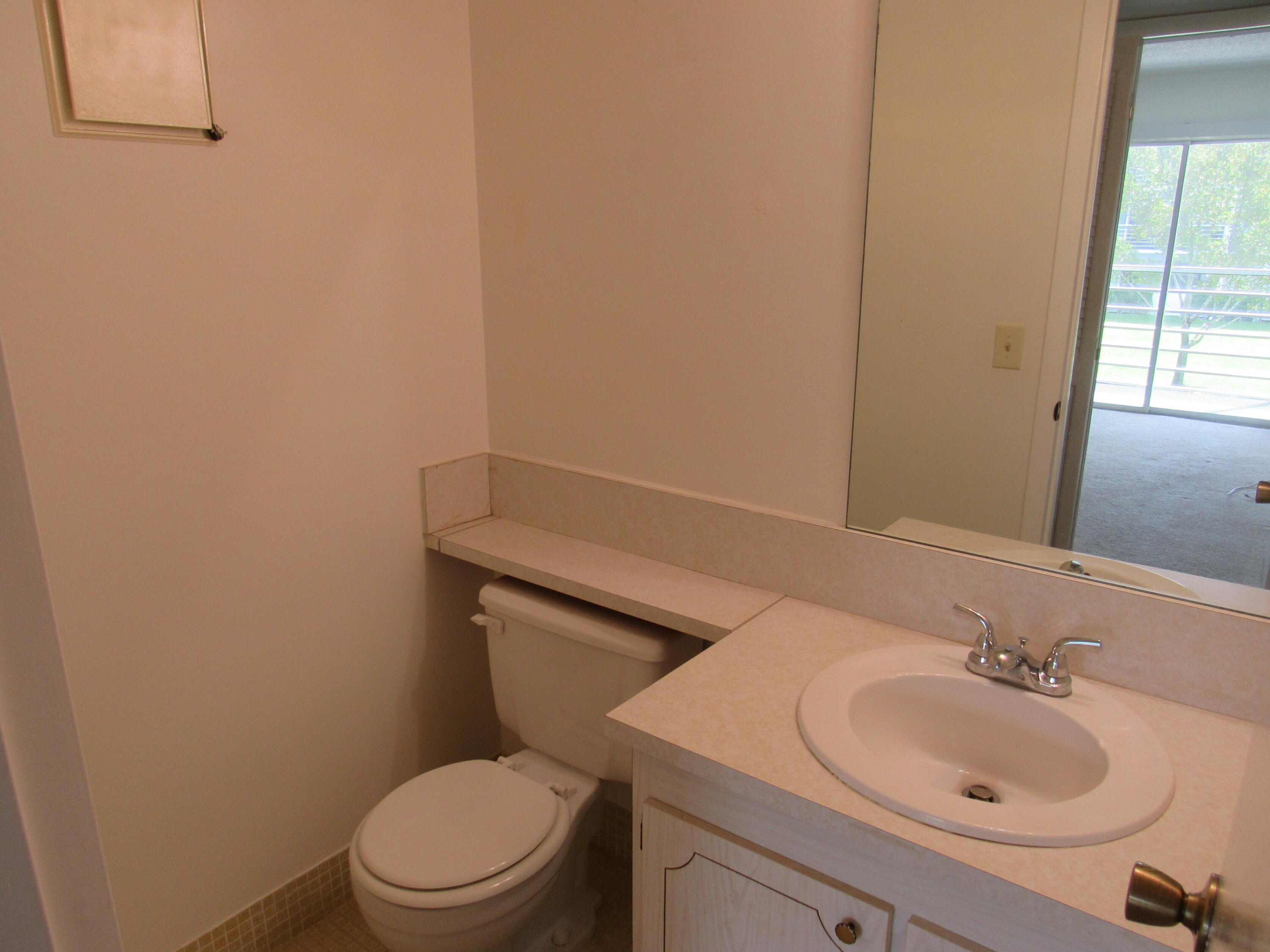 310 Brighton H Boca Raton, FL 33434 - Photo 22 of 41 a bathroom with a sink a toilet and mirror
