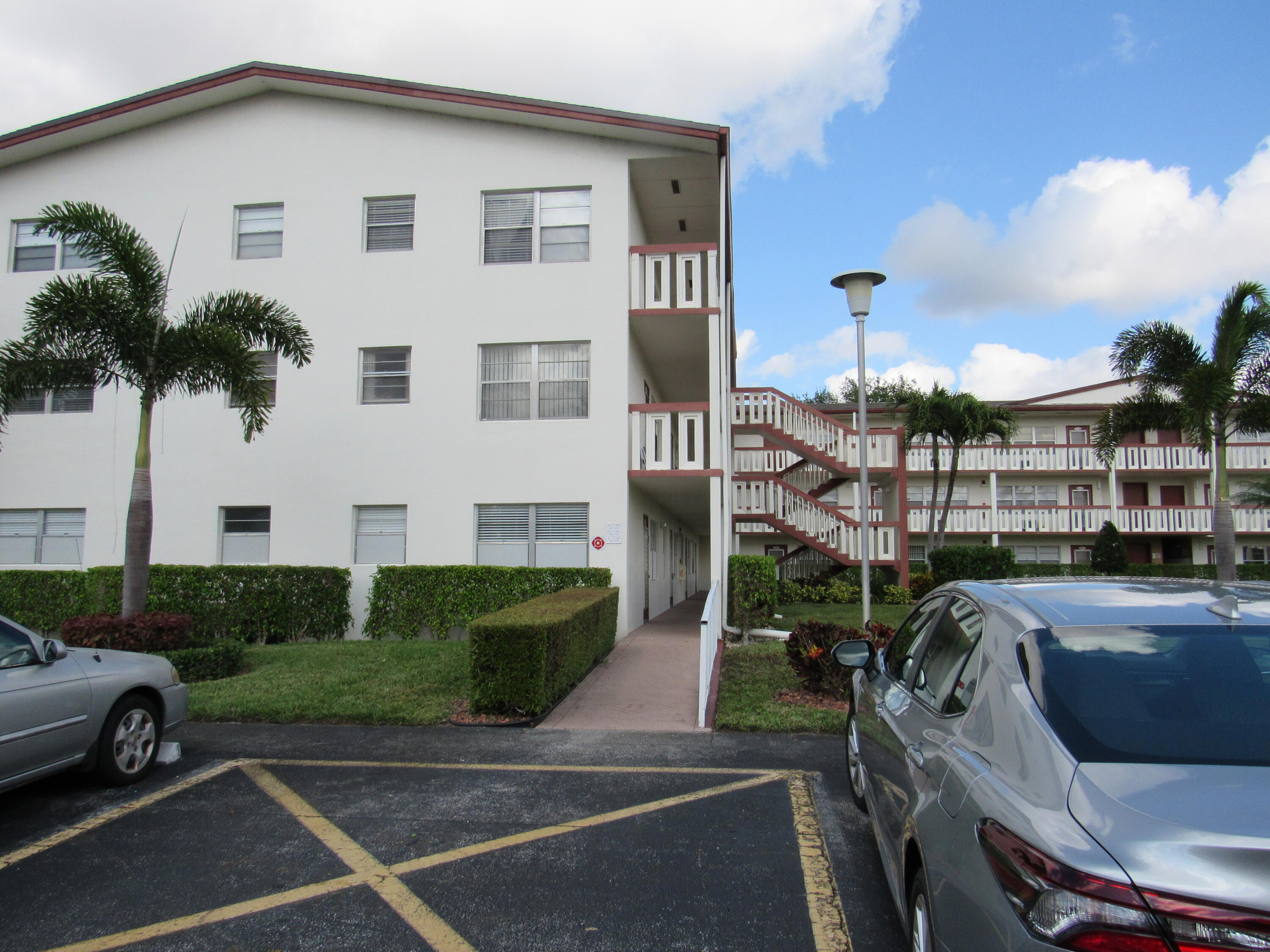 310 Brighton H Boca Raton, FL 33434 - Photo 4 of 41 a view of a white house with a yard table and chairs