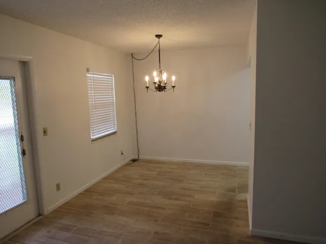 a view of an empty room with window and hallway