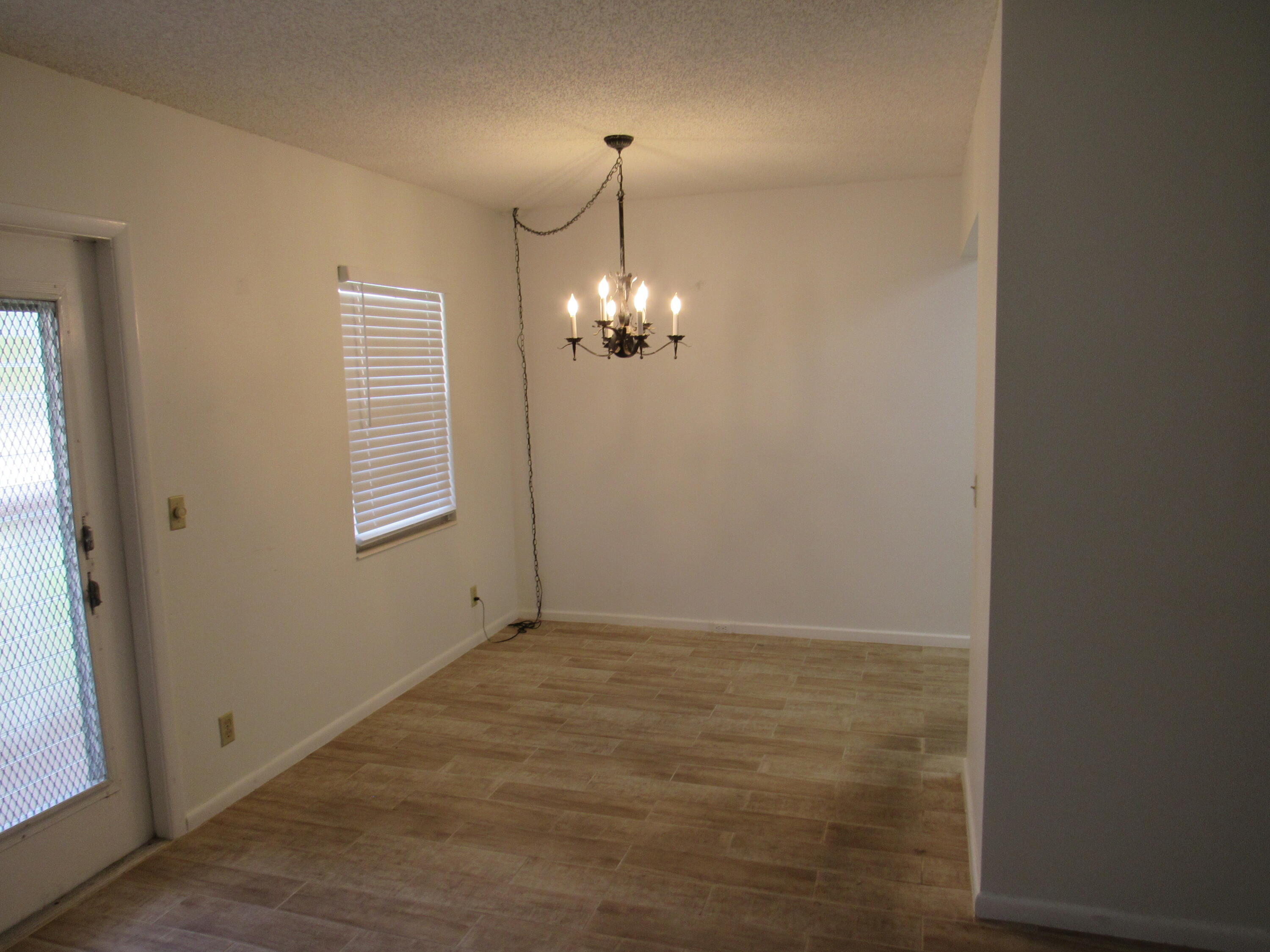 310 Brighton H Boca Raton, FL 33434 - Photo 10 of 41 a view of an empty room with window and hallway