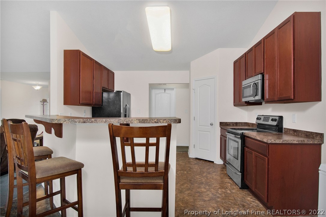 166 Hayden Road Fairmont, NC 28340 - Photo 14 of 37 a kitchen with stainless steel appliances granite countertop a stove top oven a refrigerator a sink and chairs