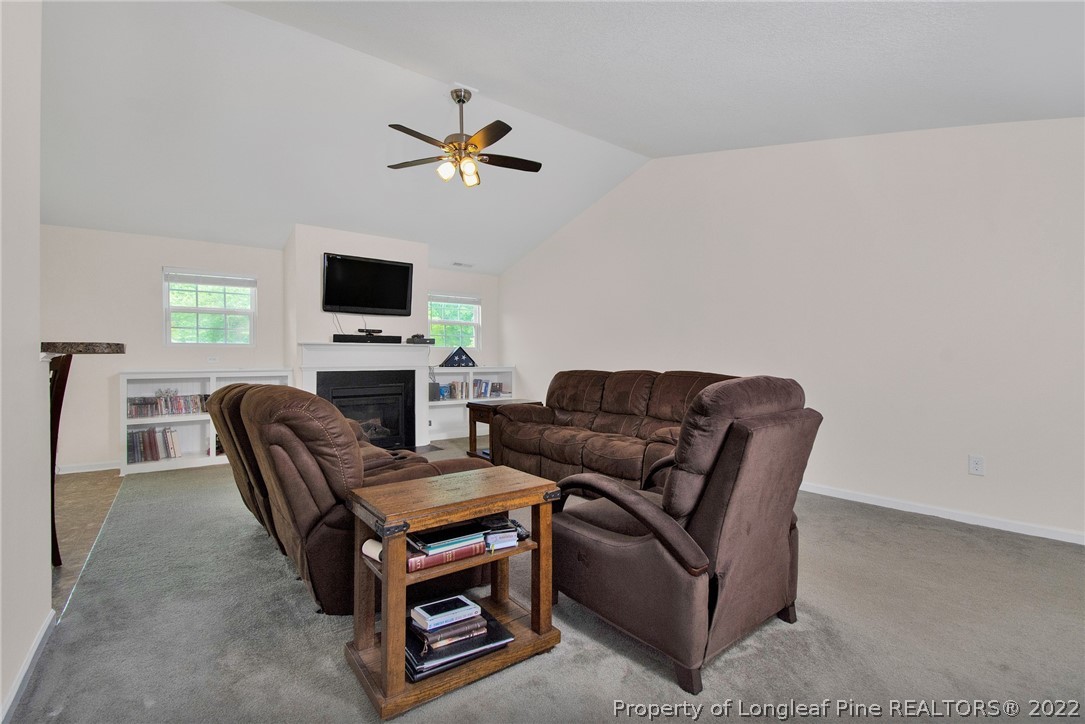 166 Hayden Road Fairmont, NC 28340 - Photo 10 of 37 a living room with furniture a fireplace and a flat screen tv