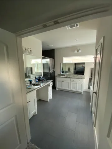 a large white kitchen with a sink stainless steel appliances and cabinets