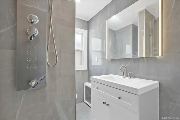 a bathroom with a sink a vanity a mirror and shower