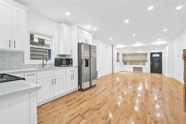 a large kitchen with kitchen island a stove a sink a refrigerator and cabinets