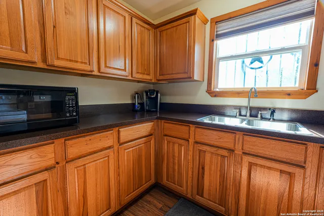 a kitchen with stainless steel appliances granite countertop wooden cabinets a sink and a granite counter top
