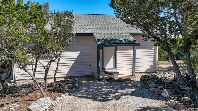 an aerial view of residential houses with outdoor space and trees