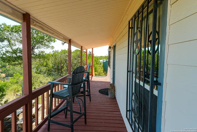 a view of a balcony with chairs and wooden floor