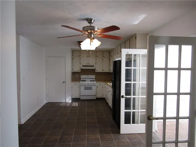 a kitchen with granite countertop a stove a sink and a refrigerator