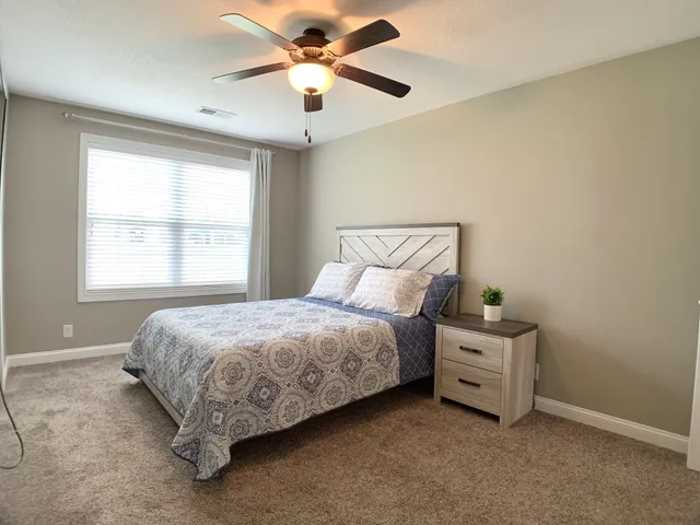 a bedroom with a bed and a ceiling fan