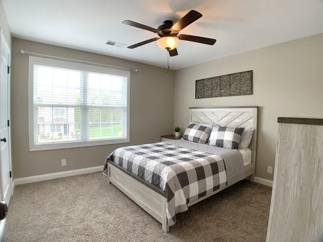 a bed sitting in a bedroom next to a window