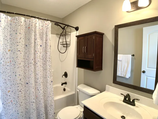 a bathroom with a sink toilet and shower