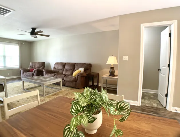 a living room with furniture a fireplace and a chandelier
