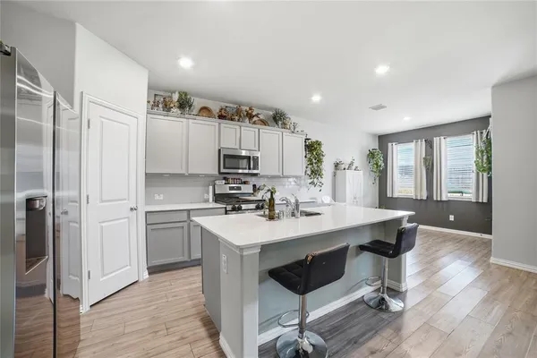 a kitchen with kitchen island a sink appliances and cabinets