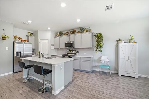 a kitchen with a sink cabinets and wooden floor