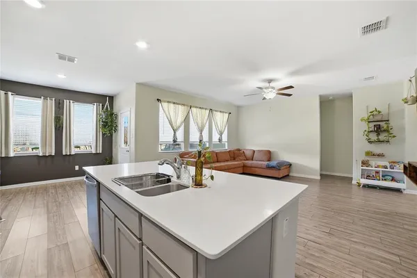 a kitchen with stainless steel appliances a stove a sink a microwave a refrigerator and cabinets