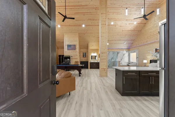 a large kitchen with kitchen island a sink a stove and a wooden floors