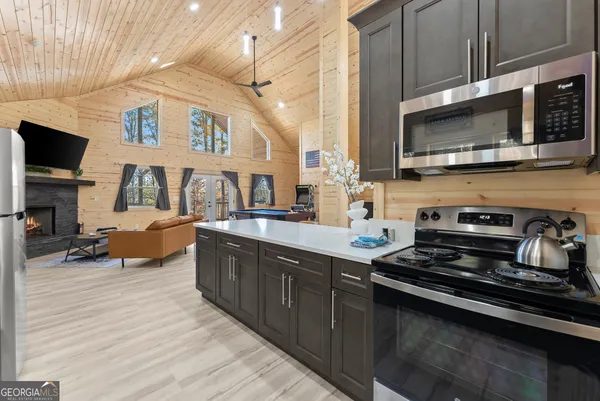 a kitchen with stainless steel appliances a stove microwave and sink