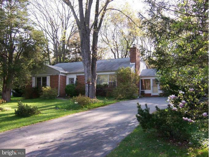 7205 Prince George Road Pikesville, MD 21207 - Photo 1 of 20 a front view of a house with a garden and trees
