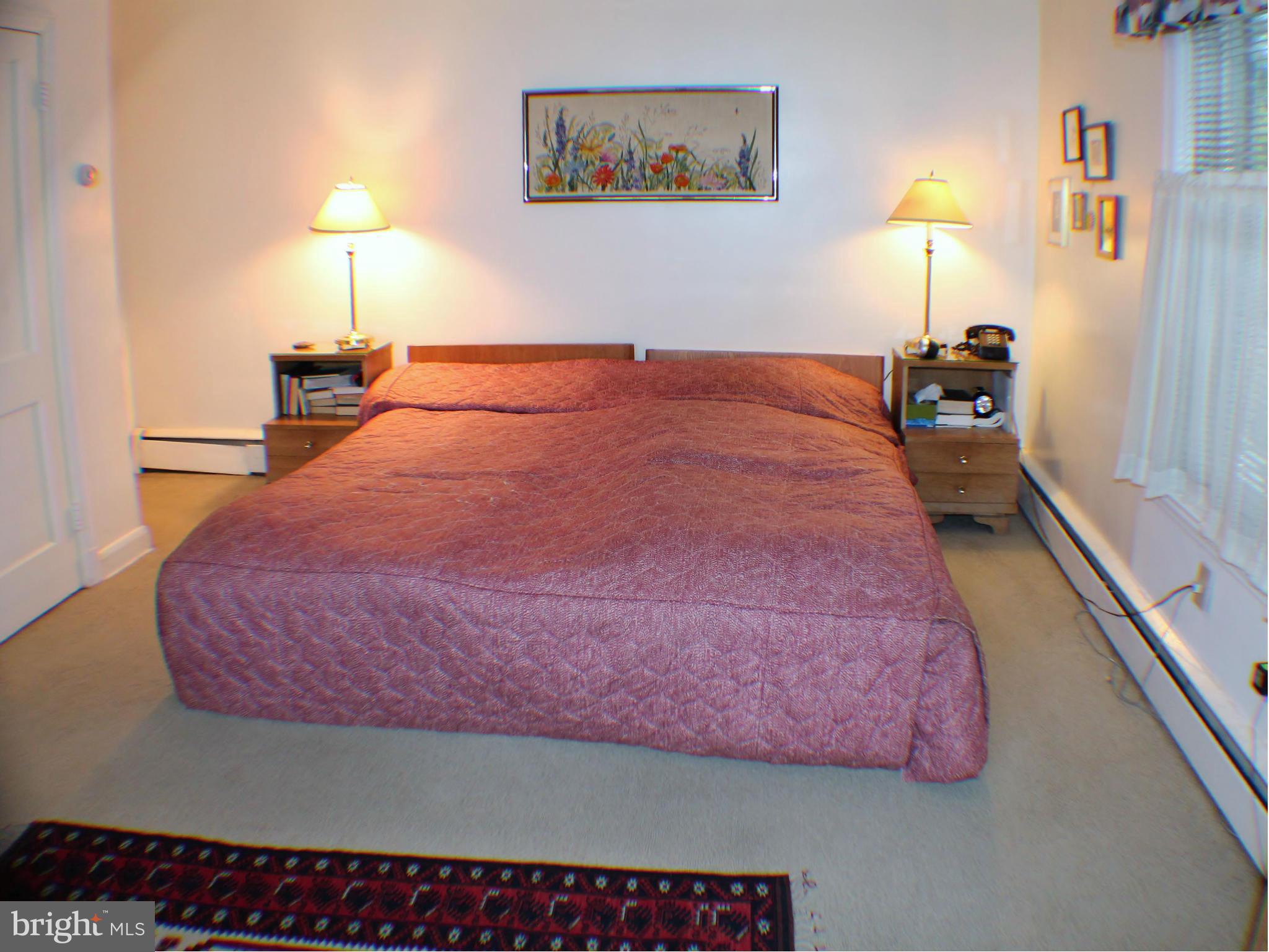 7205 Prince George Road Pikesville, MD 21207 - Photo 8 of 20 a bedroom with a bed and a lamp on table